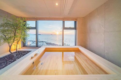 a bath tub with a view of the ocean at Yeonhwamoon Hotel Byeonsan in Buan