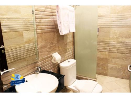 a bathroom with a toilet and a sink and a shower at PLUM Dreamscape Inan Malang in Rampal
