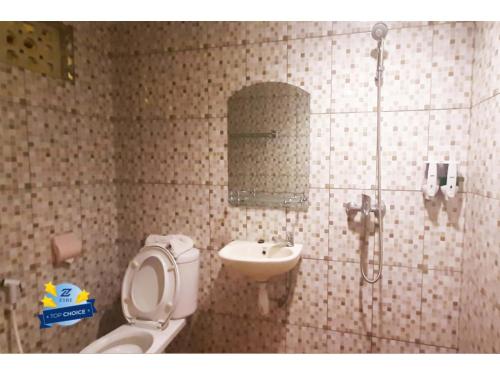 a bathroom with a toilet and a sink at PLUM Dreamscape Inan Malang in Rampal