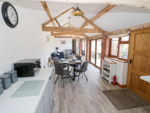 a kitchen and living room with a table and chairs at The Cow Shed in Worcester