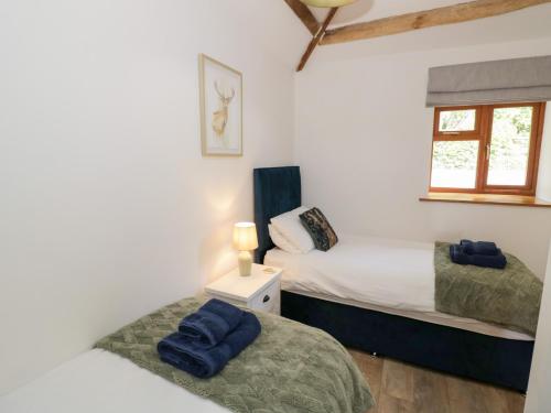 a twin bedroom with two beds and a window at The Cow Shed in Worcester