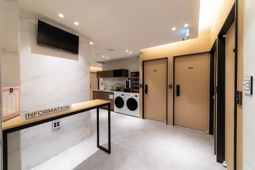 a room with a hallway with lockers and a television at The Central Hongdae in Seoul