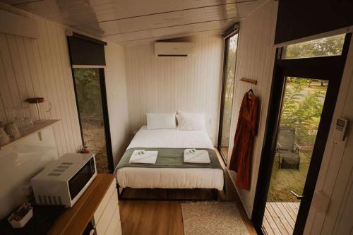 a small bedroom with a bed and a television at Monto Magic by Tiny Away in Monto