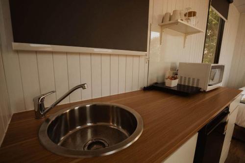 a kitchen with a sink and a laptop on a counter at Monto Magic by Tiny Away in Monto