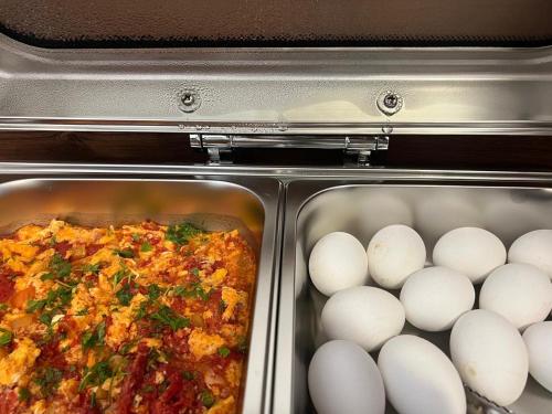 an open oven with eggs and food in it at Horizon Hotel Yerevan in Yerevan