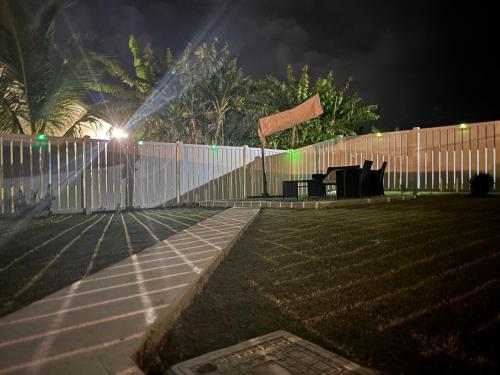 a fence at night with a fence with lights on it at Aquamarine Resort-style Vacations in Lucea