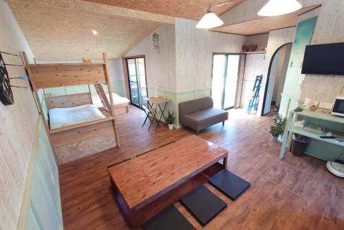 Zimmer mit einem Tisch, einem Bett und einem Schreibtisch in der Unterkunft Hyuga Surf Camp107 - Vacation STAY 29756v in Hyuga