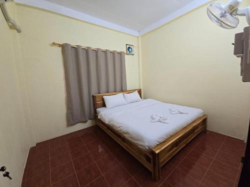 Un dormitorio pequeño con una cama con sábanas blancas. en Mary's House Visoun, en Luang Prabang