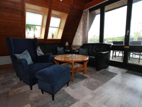 a living room with chairs and a table and windows at Ferienhaus mit Terrasse, Haustierfrei in Clausthal-Zellerfeld