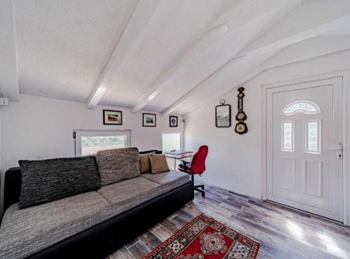a living room with a couch and a red chair at Natur Olive House Ston in Ston