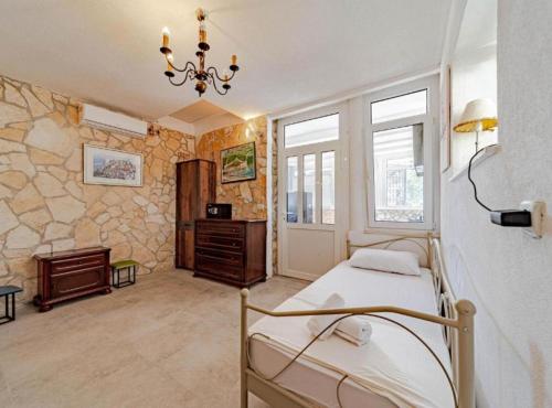 a bedroom with a bed in a room with stone walls at Natur Olive House Ston in Ston