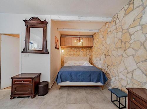 a bedroom with a bed and a stone wall at Natur Olive House Ston in Ston