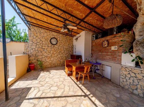 a patio with a wooden table and a stone wall at Natur Olive House Ston in Ston