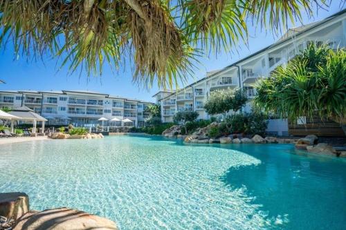 a swimming pool in front of a resort at The Pool Resort Kingscliff - Private Apartments by Holiday Management Company in Kingscliff