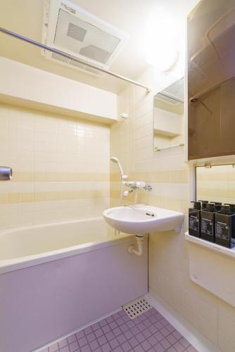a bathroom with a sink and a bath tub at 栄エリア徒歩圏の好立地 栄まで1駅 名古屋駅まで乗換不要 地下鉄最寄り駅徒歩9分 最大5名 in Nagoya