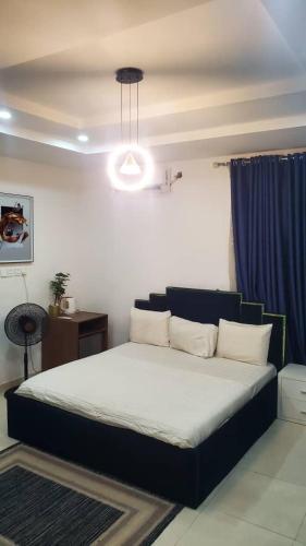 a bedroom with a large bed with a blue curtain at Abuja luxury apartment in Abuja