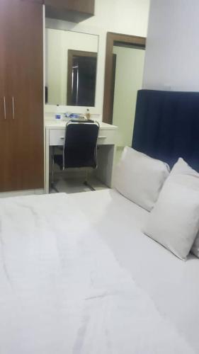 a bedroom with a bed and a desk with a computer at Abuja luxury apartment in Abuja