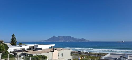 Una vista de la playa con casas y el océano. en 2WhiteWaters Bloubergstrand Homestay, en Bloubergstrand