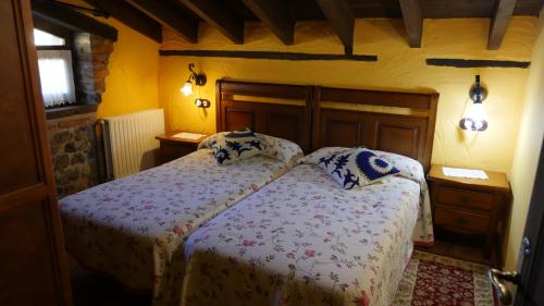 a bedroom with a bed with two pillows on it at Hotel Rural Los Texos in La Riera