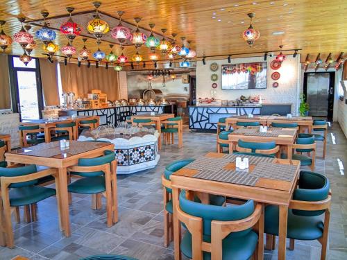 a restaurant with wooden tables and chairs and a counter at Petra Bermudez Hotel in Wadi Musa