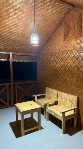 a room with two benches and a table in it at Jabal Hatt Resthouse in Khawr Zammah