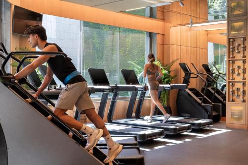 a man and woman running on a treadmill in a gym at Shangri-La Eros New Delhi in New Delhi