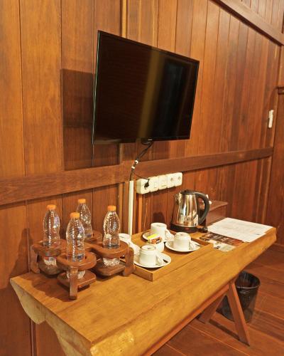 a wooden table with a television on a wall at Kasuari Exotic Resort Magelang in Magelang