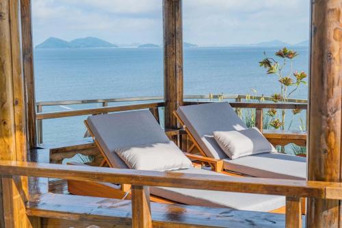 two lounge chairs sitting on a porch overlooking the ocean at Yeonhwamoon Hotel Byeonsan in Buan