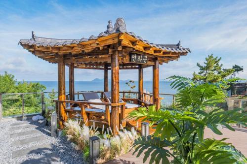 a wooden gazebo with the ocean in the background at Yeonhwamoon Hotel Byeonsan in Buan
