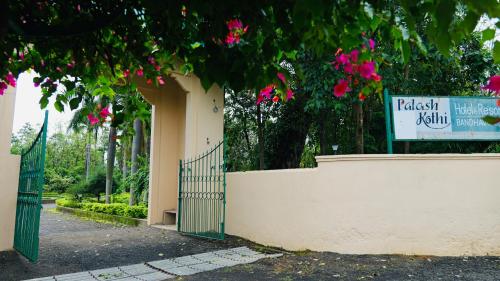 a sign for a park with a gate and pink flowers at Palash Kothi -Bandhavgarh in Tāla
