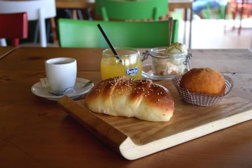a table with a cutting board with a loaf of bread and a muffin at La Casa del Geko in Cefalù