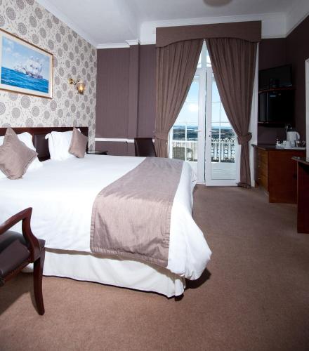 a hotel room with a large bed and a balcony at Pontac House Hotel in St Clements