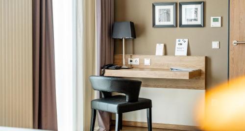 a chair sitting at a desk in a hotel room at Best Western Plus Hotel Ostertor in Bad Salzuflen