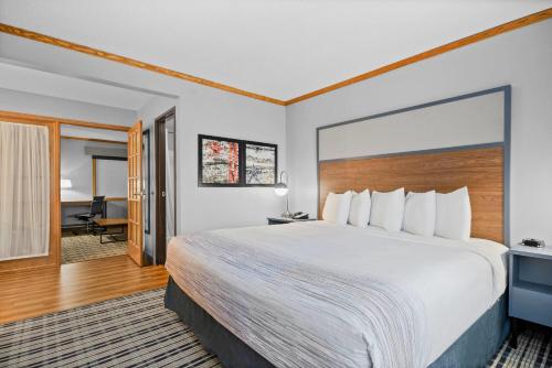 a hotel room with a large bed and a desk at AmericInn by Wyndham Virginia in Virginia