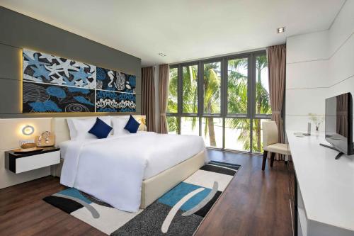 a bedroom with a large white bed and a tv at Ocean Villas Da Nang in Danang