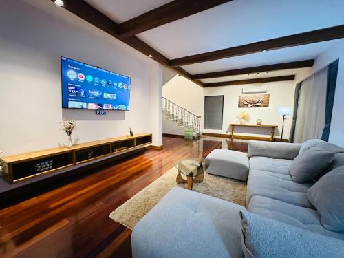 a living room with a couch and a tv at Ploythai Villa Koh Phangan in Haad Pleayleam