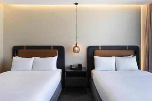 two beds sitting next to each other in a room at Hilton Guadalajara Midtown in Guadalajara