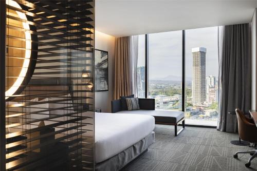 a hotel room with a bed and a large window at Hilton Guadalajara Midtown in Guadalajara