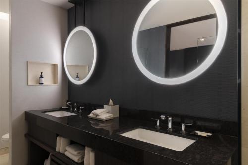 a bathroom with two sinks and a large mirror at Hilton Guadalajara Midtown in Guadalajara