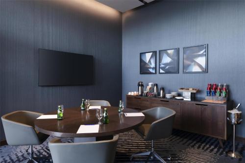 a conference room with a table and chairs and a television at Hilton Guadalajara Midtown in Guadalajara