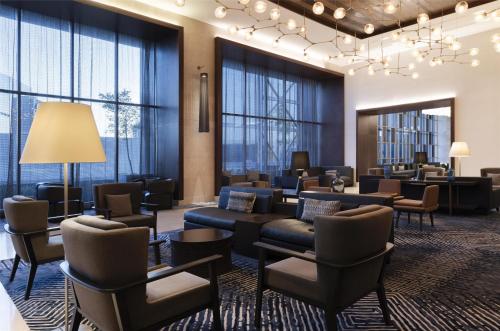 a waiting room with couches and chairs and windows at Hilton Guadalajara Midtown in Guadalajara