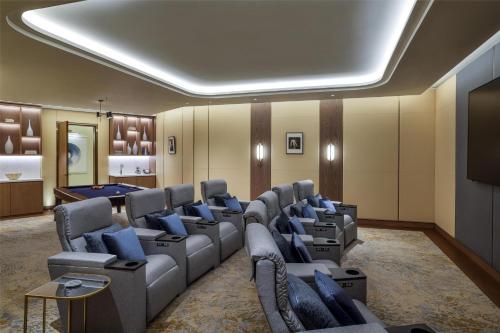 a waiting room with couches and a flat screen tv at Waldorf Astoria Doha Lusail in Doha