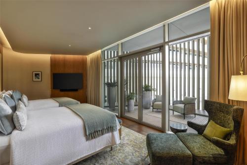 a hotel room with a bed and a balcony at Waldorf Astoria Doha Lusail in Doha