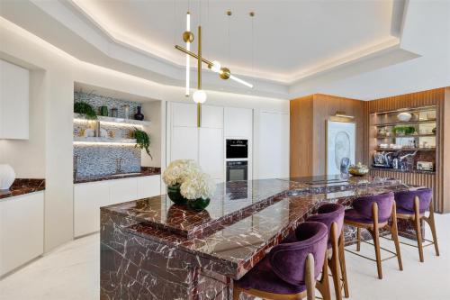 a kitchen with a marble counter and purple stools at Waldorf Astoria Doha Lusail in Doha