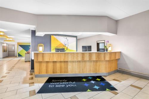 a lobby with a reception desk and a welcome mat at Spark by Hilton Roanoke Civic Center in Roanoke