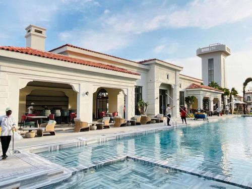 a pool at a hotel with people walking around it at Villa Hồ Tràm 3636 in Xuyên Mộc