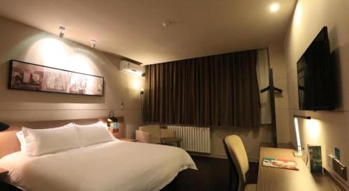 a hotel room with a large white bed and a chair at Jinjiang Inn Xi'an Zhonglou North Street Metro Station in Xi'an