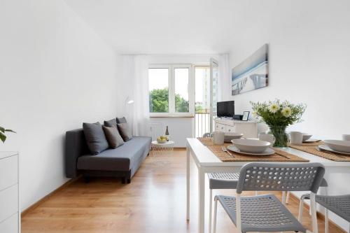 ein Wohnzimmer mit Sofa und Tisch in der Unterkunft Ivory Nature & Beachside by Elite Apartments in Przymorze