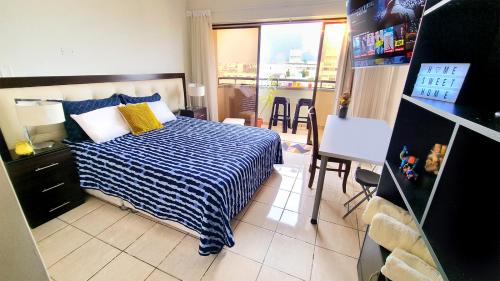 a bedroom with a bed with a blue and white striped blanket at Habitación en casa de Luis con espacios compartidos in Lima