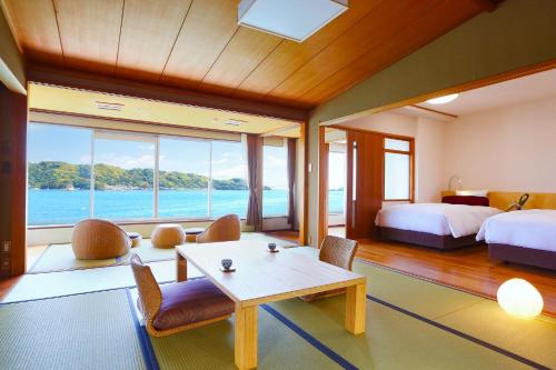 a bedroom with two beds and a table and chairs at Ooedo Onsen Monogatari Nanki Kushimoto in Kushimoto